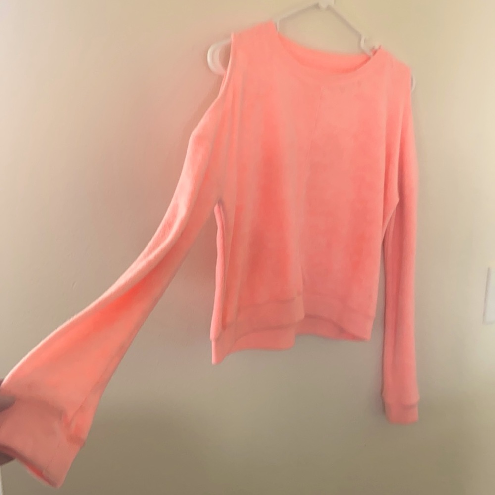 Salmon sweatshirt with cutout shoulders.